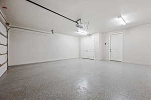 Garage featuring baseboards and a garage door opener