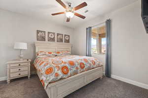 Carpeted bedroom with baseboards and a ceiling fan