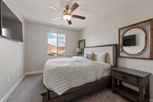 Carpeted bedroom featuring baseboards and a ceiling fan