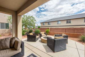 View of patio / terrace featuring an outdoor living space with a fire pit and fence