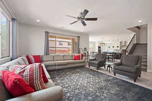 Living area with plenty of natural light, a ceiling fan, stairway, and recessed lighting