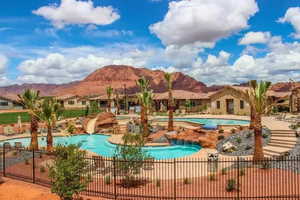 Community pool with fence, a mountain view, and a patio