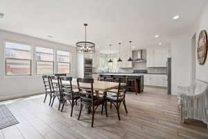 Dining area featuring a chandelier, light wood finished floors, recessed lighting, and baseboards