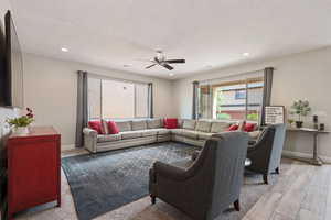 Living area featuring ceiling fan, recessed lighting, baseboards, and light wood-style flooring