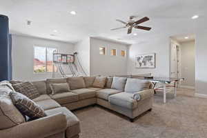 Living area with recessed lighting, light colored carpet, a ceiling fan, and baseboards