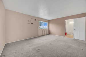 Carpeted spare room featuring baseboards
