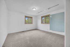 Empty room featuring carpet and a textured ceiling