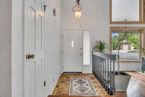 Foyer featuring a towering ceiling and baseboards