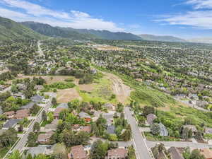 Aerial view of property's location with a mountain backdrop and nearby suburban area