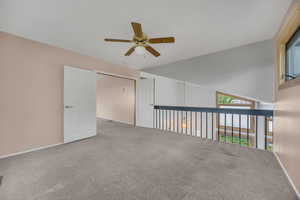 Carpeted empty room with a ceiling fan and baseboards