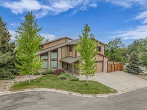 Mid-century home with concrete driveway, a front lawn, and brick siding