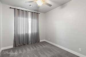 Empty room featuring baseboards, ceiling fan, and carpet flooring