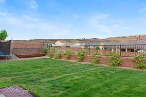 View of yard with a trampoline and a residential view