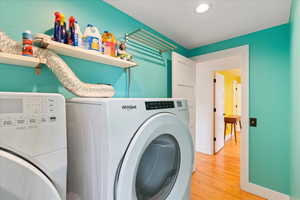 Washroom with independent washer and dryer, light wood-style floors, baseboards, and recessed lighting