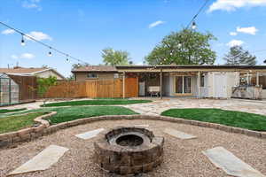 Back of house with an outdoor fire pit and a patio area