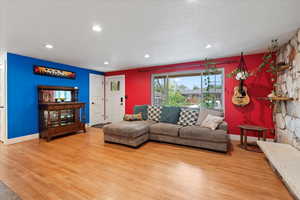 Living room with wood finished floors, baseboards, and recessed lighting