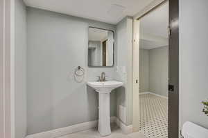 Half bathroom with toilet and baseboards