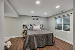 Bedroom with baseboards, wood finished floors, and recessed lighting