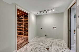 Washroom with hookup for an electric dryer, washer hookup, and baseboards