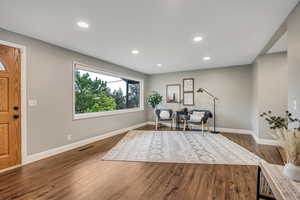 Foyer with baseboards, dark wood-type flooring, and recessed lighting