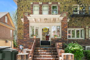 Doorway to property featuring brick siding