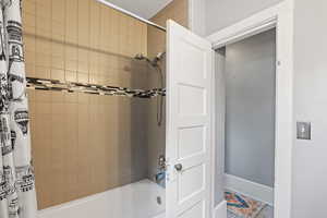 Bathroom with shower / tub combo with curtain and baseboards