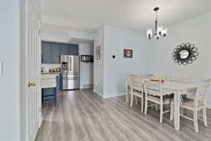Dining space featuring wood finished floors, baseboards, and a chandelier