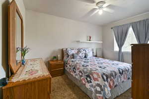 Carpeted bedroom featuring ceiling fan