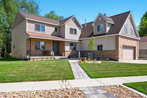 View of front of property featuring a porch, a front yard, a garage, and brick siding