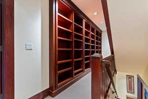 Hallway featuring an upstairs landing, carpet floors, and recessed lighting
