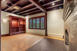 Unfurnished living room featuring wooden ceiling, baseboards, beam ceiling, and wood finished floors