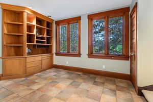 Unfurnished room featuring baseboards and light stone finish flooring