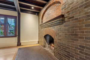 Unfurnished living room with beam ceiling and wood finished floors