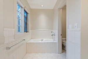 Bathroom featuring toilet, a bath, and tile patterned flooring