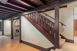 Below grade area featuring baseboards, wood finished floors, stairway, wood ceiling, and a fireplace