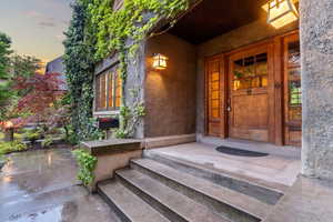 Exterior entry at dusk featuring stucco siding