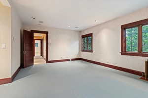 Carpeted empty room with baseboards and recessed lighting