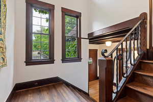 Stairs with wood finished floors and baseboards