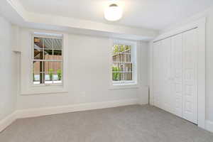 Unfurnished bedroom with carpet, a closet, and baseboards