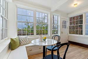 Sunroom with beam ceiling and a water view