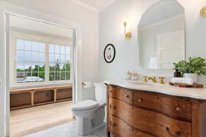 Bathroom with crown molding, toilet, and vanity