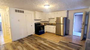 Kitchen/Dining featuring New Range and Refrigerator., New Wood grain Laminate Flooring.