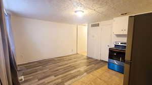 Kitchen/Dining featuring New Range and Refrigerator., New Wood grain Laminate Flooring.