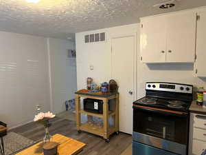 Kitchen/Dining featuring New Range and Refrigerator., New Wood grain Laminate Flooring.