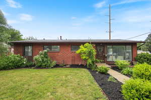 Single story home featuring a front lawn and brick siding