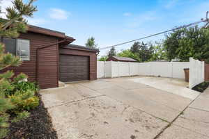 Garage featuring fence and driveway