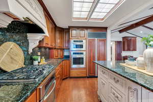 Kitchen has double ovens, gas range, and beautiful granite countertops