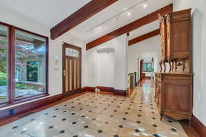 Grand entrance with marble floor, custom door, beams
