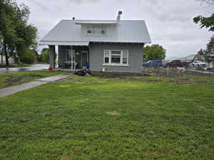 View of front of house featuring stucco siding and metal roof