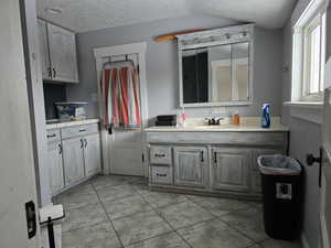 Bathroom with a textured ceiling and vanity